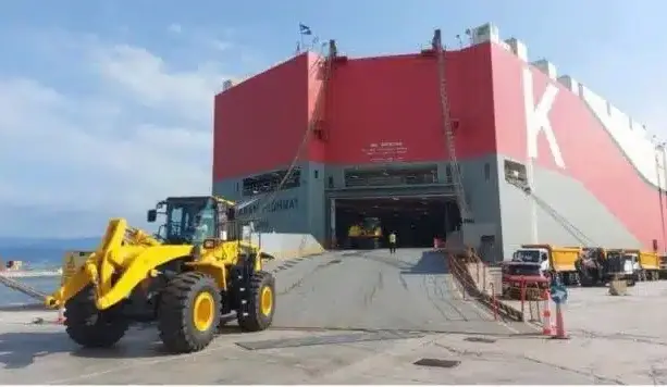 Construction machinery driving onto a RoRo vessel for shipping to Africa